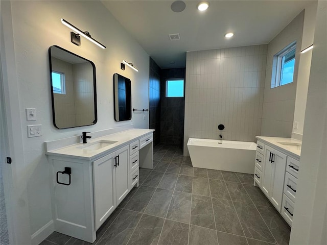 bathroom with tile patterned floors, vanity, shower with separate bathtub, and tile walls