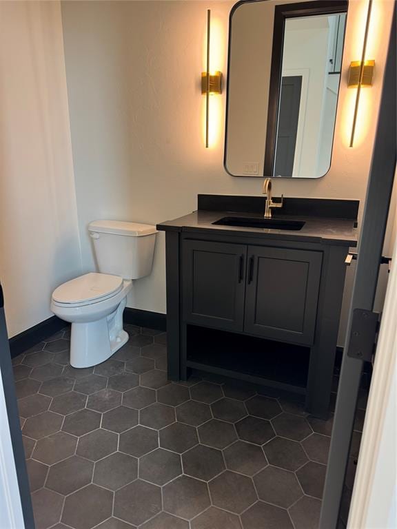 bathroom featuring tile patterned flooring, vanity, and toilet