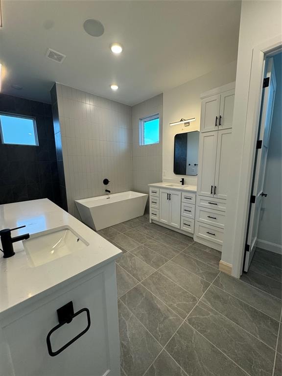 bathroom with a tub to relax in and vanity