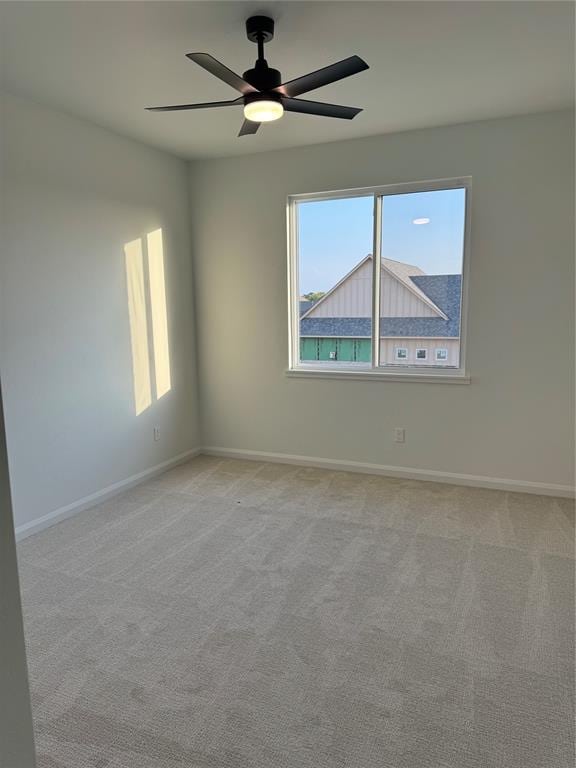 empty room featuring ceiling fan and light colored carpet