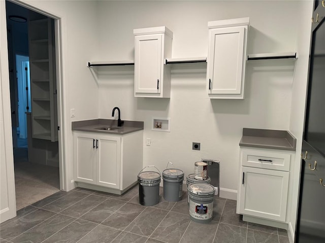 washroom featuring electric dryer hookup, hookup for a washing machine, sink, and cabinets