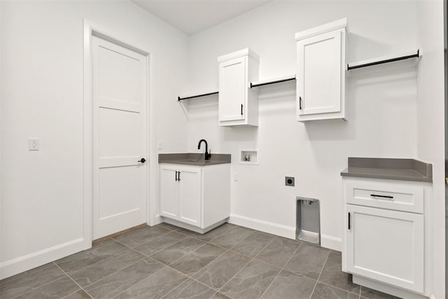 laundry room featuring baseboards, washer hookup, cabinet space, electric dryer hookup, and a sink