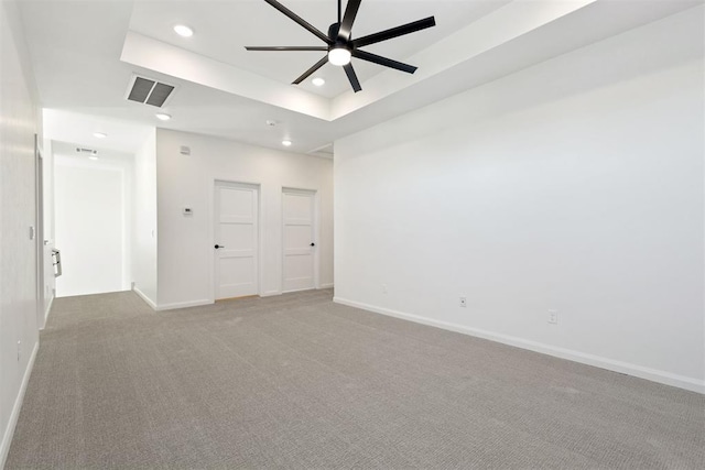 carpeted spare room with baseboards, visible vents, recessed lighting, ceiling fan, and a raised ceiling