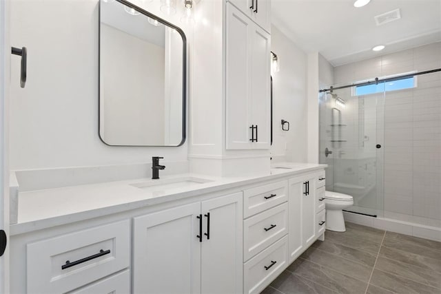 full bath featuring double vanity, visible vents, a shower stall, and a sink