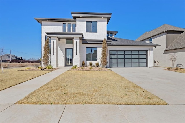 view of front of property with a front yard, a garage, brick siding, and driveway