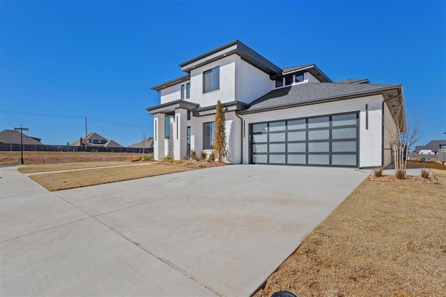 view of front of home with brick siding, driveway, and a garage