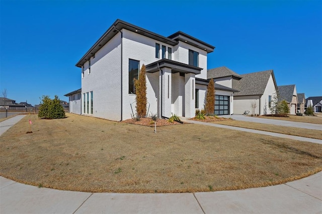 view of front facade with a residential view, a front lawn, brick siding, and driveway