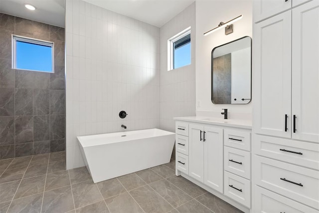 bathroom with vanity, tile walls, a soaking tub, and a walk in shower