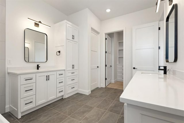 full bathroom featuring recessed lighting, a walk in closet, and vanity