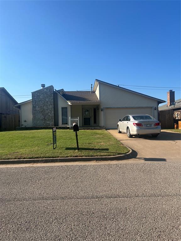 ranch-style house featuring a garage and a front lawn