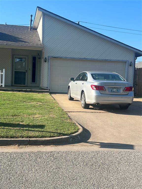 ranch-style house featuring a garage and a front lawn