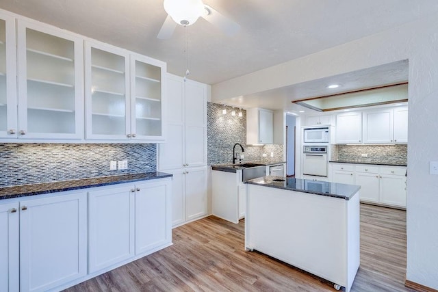 kitchen featuring white cabinetry, white appliances, and tasteful backsplash