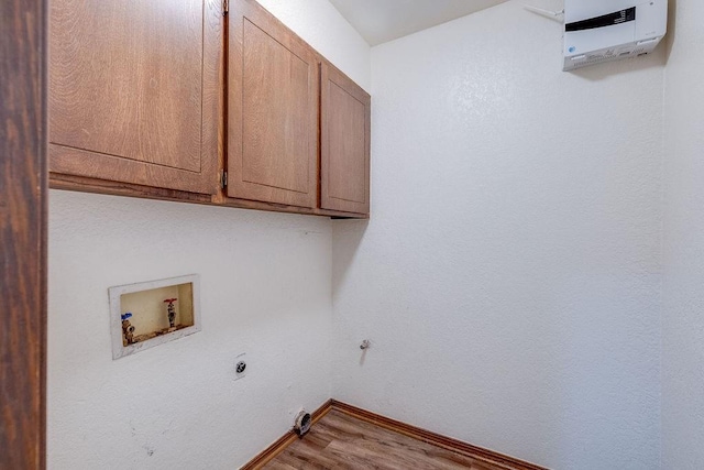 clothes washing area with washer hookup, electric dryer hookup, cabinets, and hardwood / wood-style floors