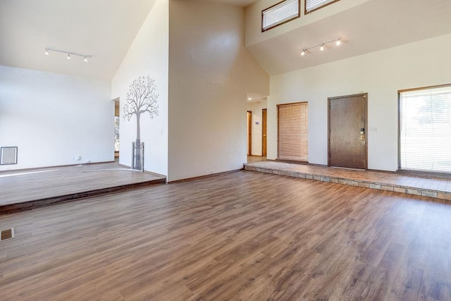 interior space featuring high vaulted ceiling, track lighting, and hardwood / wood-style flooring