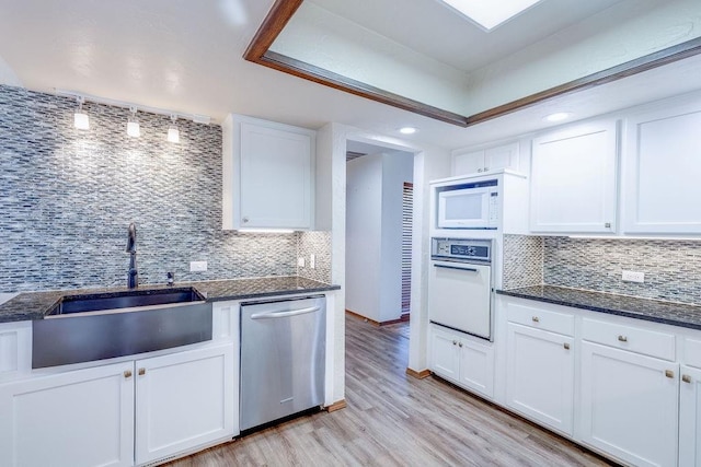 kitchen featuring tasteful backsplash, white cabinets, white appliances, and light wood-type flooring