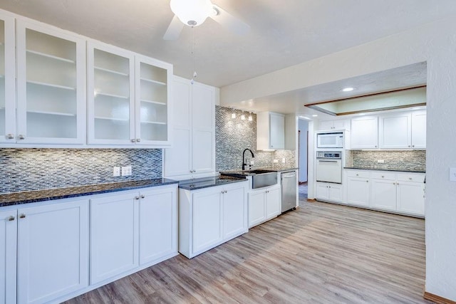 kitchen featuring backsplash, sink, white appliances, and light wood-type flooring