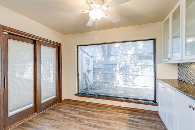 unfurnished dining area featuring ceiling fan and light hardwood / wood-style floors