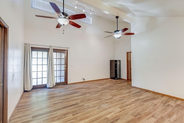 unfurnished living room with ceiling fan, high vaulted ceiling, and light hardwood / wood-style floors