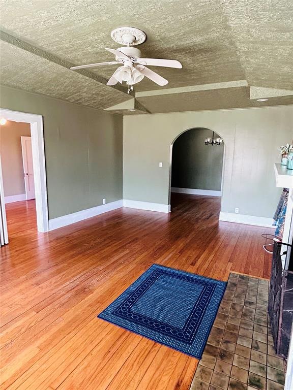 interior space featuring vaulted ceiling, ceiling fan, hardwood / wood-style floors, and a textured ceiling