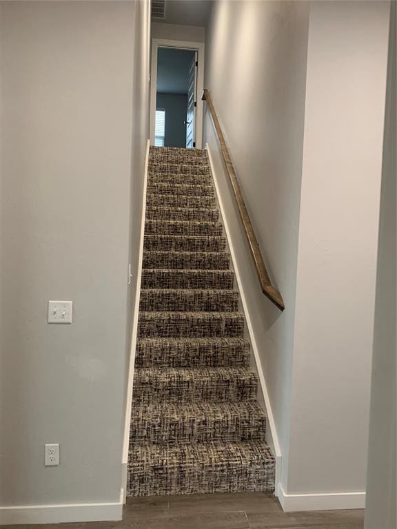 staircase with hardwood / wood-style flooring