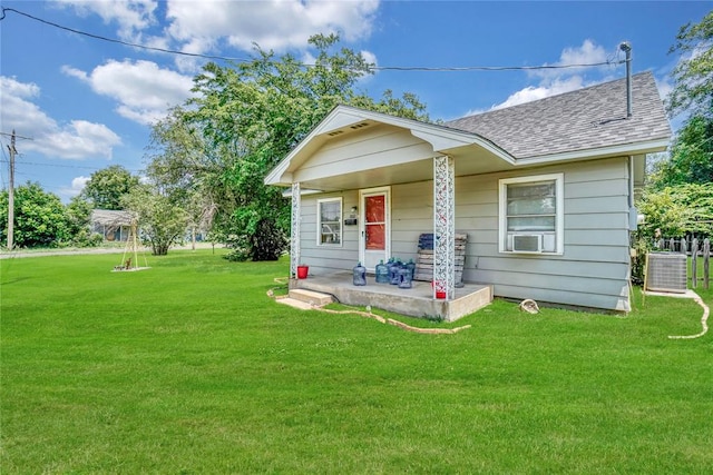 back of property with central air condition unit, a yard, and a porch