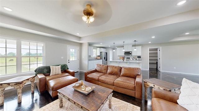 living room featuring ceiling fan and dark hardwood / wood-style flooring