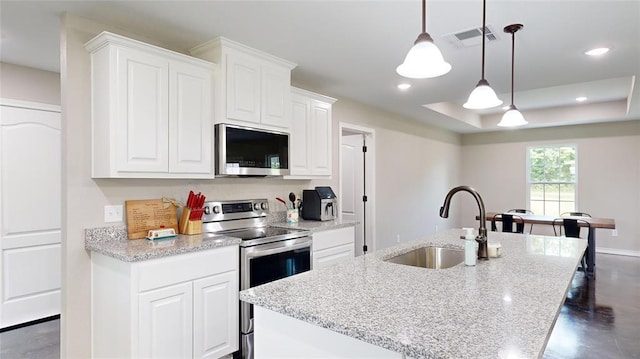 kitchen with sink, white cabinets, hanging light fixtures, and appliances with stainless steel finishes