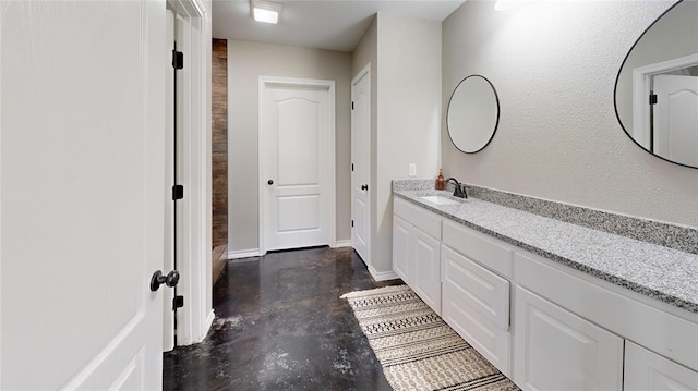 bathroom with vanity and concrete flooring