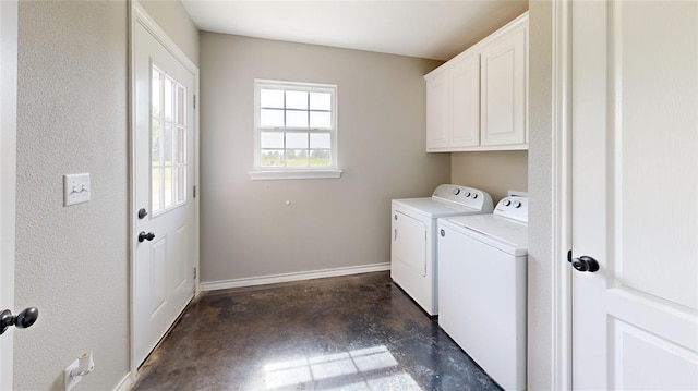 laundry room featuring washing machine and clothes dryer and cabinets