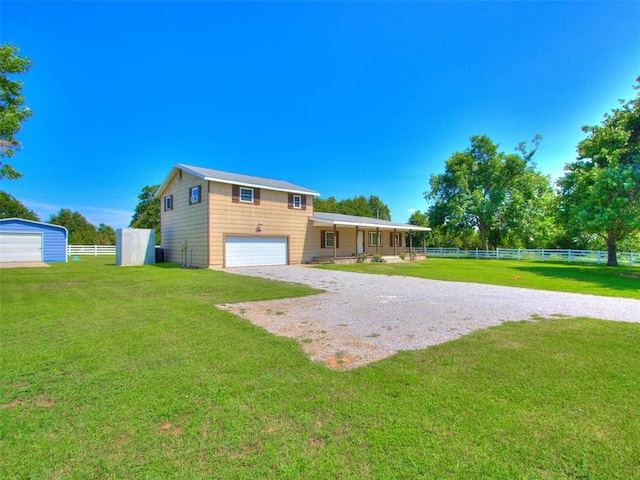 rear view of property featuring a garage and a yard