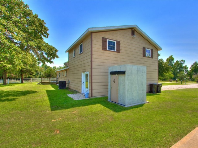 back of house featuring central AC and a lawn