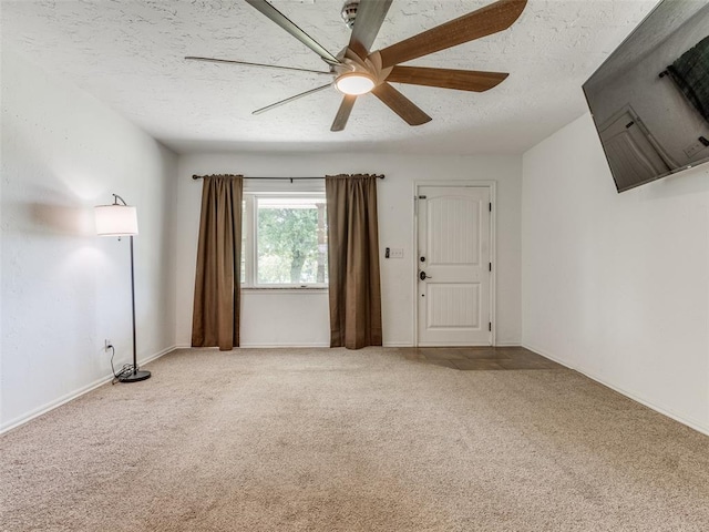 carpeted spare room with ceiling fan and a textured ceiling