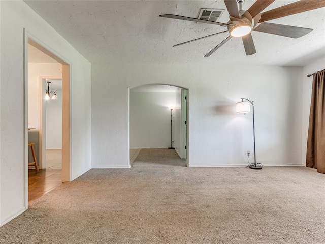 carpeted spare room with a textured ceiling and ceiling fan with notable chandelier