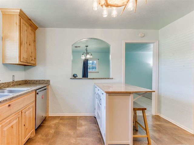 kitchen featuring a kitchen bar, kitchen peninsula, light brown cabinets, and stainless steel dishwasher