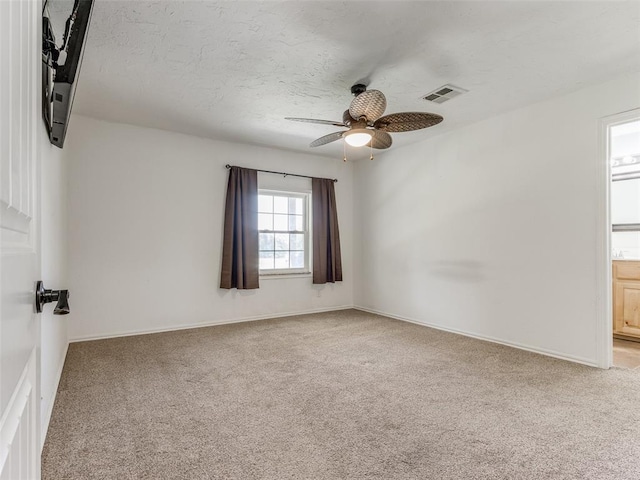 carpeted empty room with ceiling fan and a textured ceiling