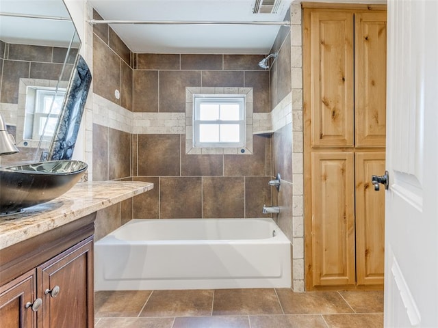 bathroom featuring tile patterned flooring, vanity, tile walls, and tiled shower / bath combo