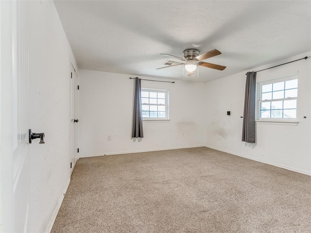 carpeted spare room featuring ceiling fan