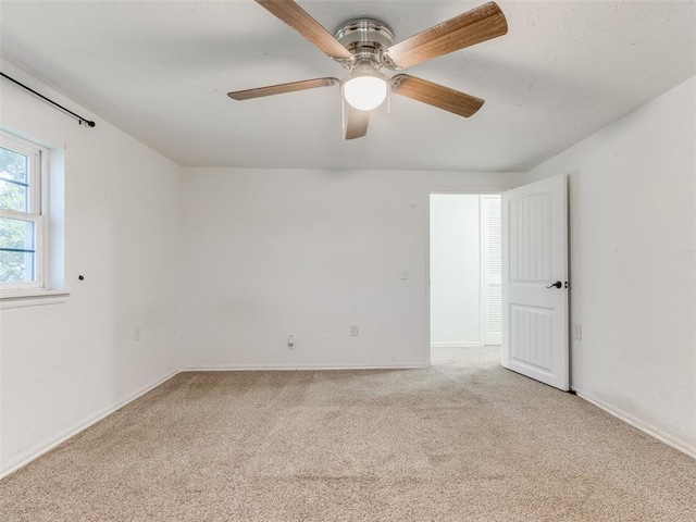 carpeted empty room featuring ceiling fan