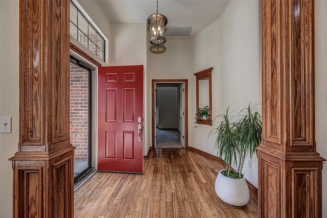 doorway featuring an inviting chandelier and light wood-type flooring