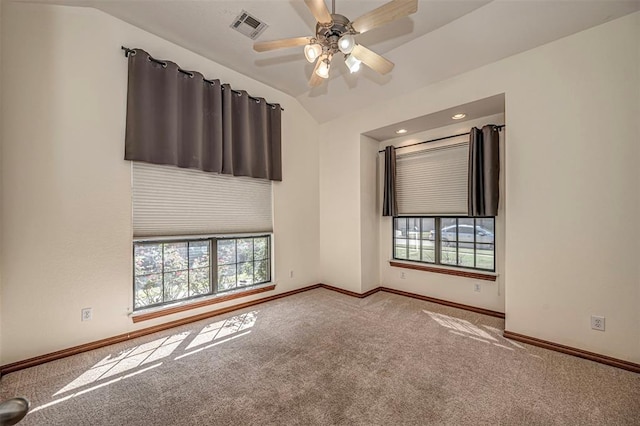 spare room with plenty of natural light, ceiling fan, light colored carpet, and vaulted ceiling