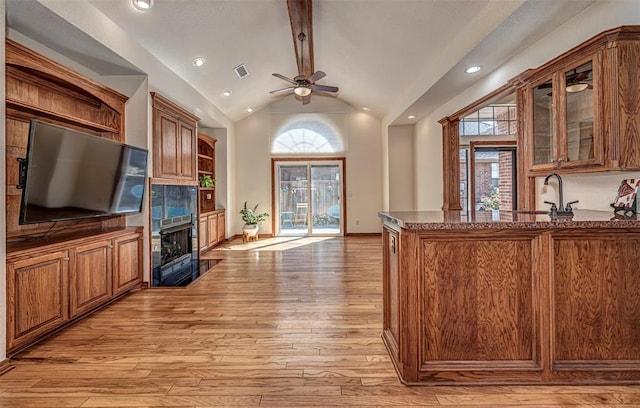 bar featuring ceiling fan, sink, light hardwood / wood-style flooring, beamed ceiling, and high vaulted ceiling