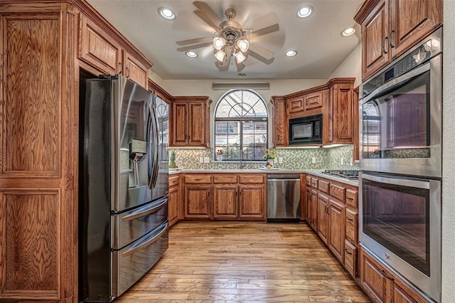 kitchen with tasteful backsplash, ceiling fan, light hardwood / wood-style flooring, and stainless steel appliances