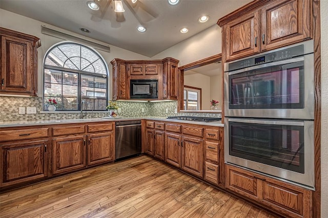 kitchen featuring backsplash, light hardwood / wood-style floors, sink, and appliances with stainless steel finishes