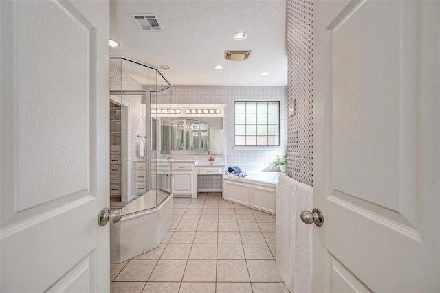 bathroom with tile patterned flooring, vanity, and a bathing tub