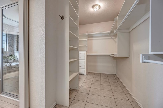 walk in closet with light tile patterned floors