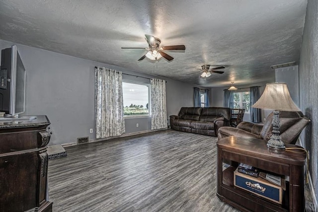 living room featuring ceiling fan, hardwood / wood-style floors, and a textured ceiling