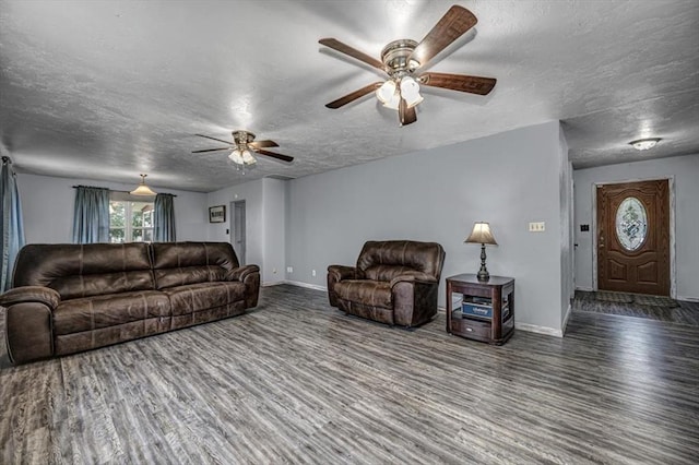 living room featuring a textured ceiling, dark hardwood / wood-style floors, and ceiling fan