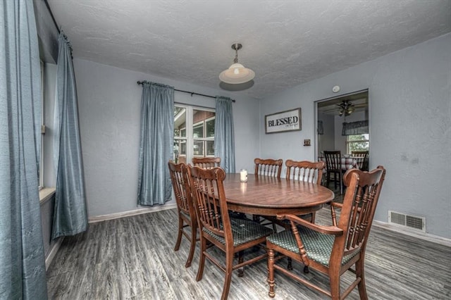 dining room featuring a textured ceiling, ceiling fan, a healthy amount of sunlight, and dark wood-type flooring