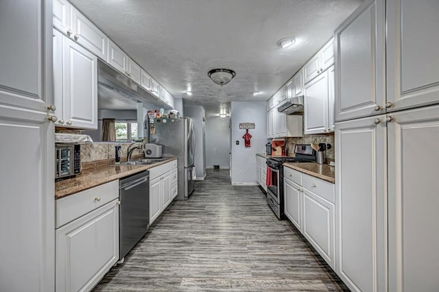 kitchen featuring stone countertops, light hardwood / wood-style floors, white cabinetry, and stainless steel appliances