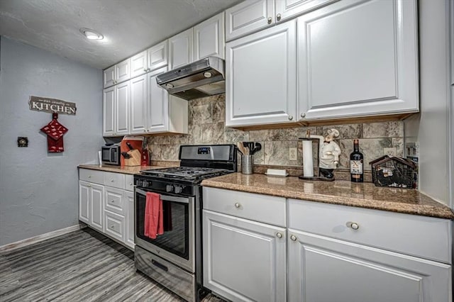 kitchen featuring white cabinets, stainless steel gas range oven, stone counters, and tasteful backsplash